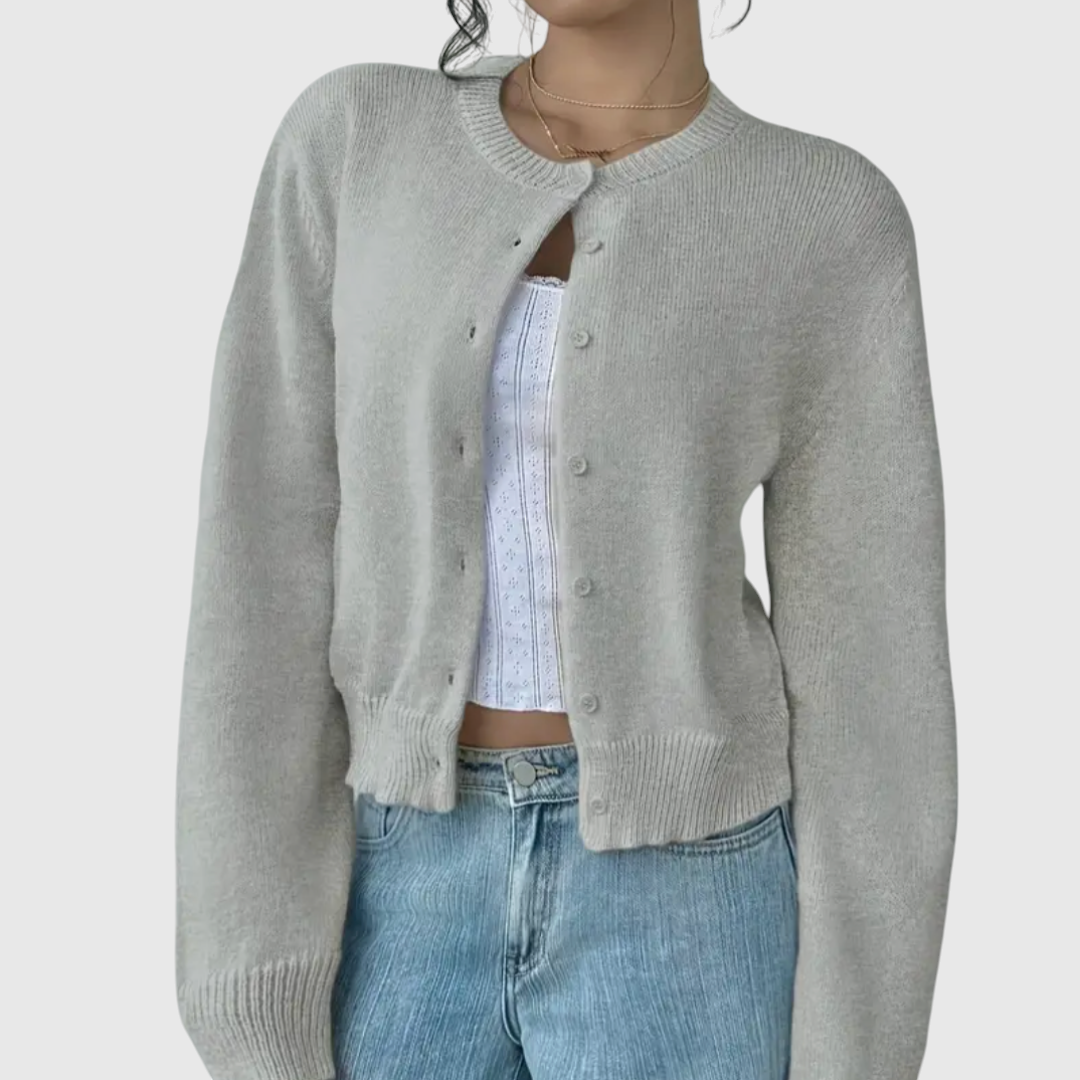 My Store Angelika cropped grey knit cardigan with a round neckline and button-down front worn over a white top