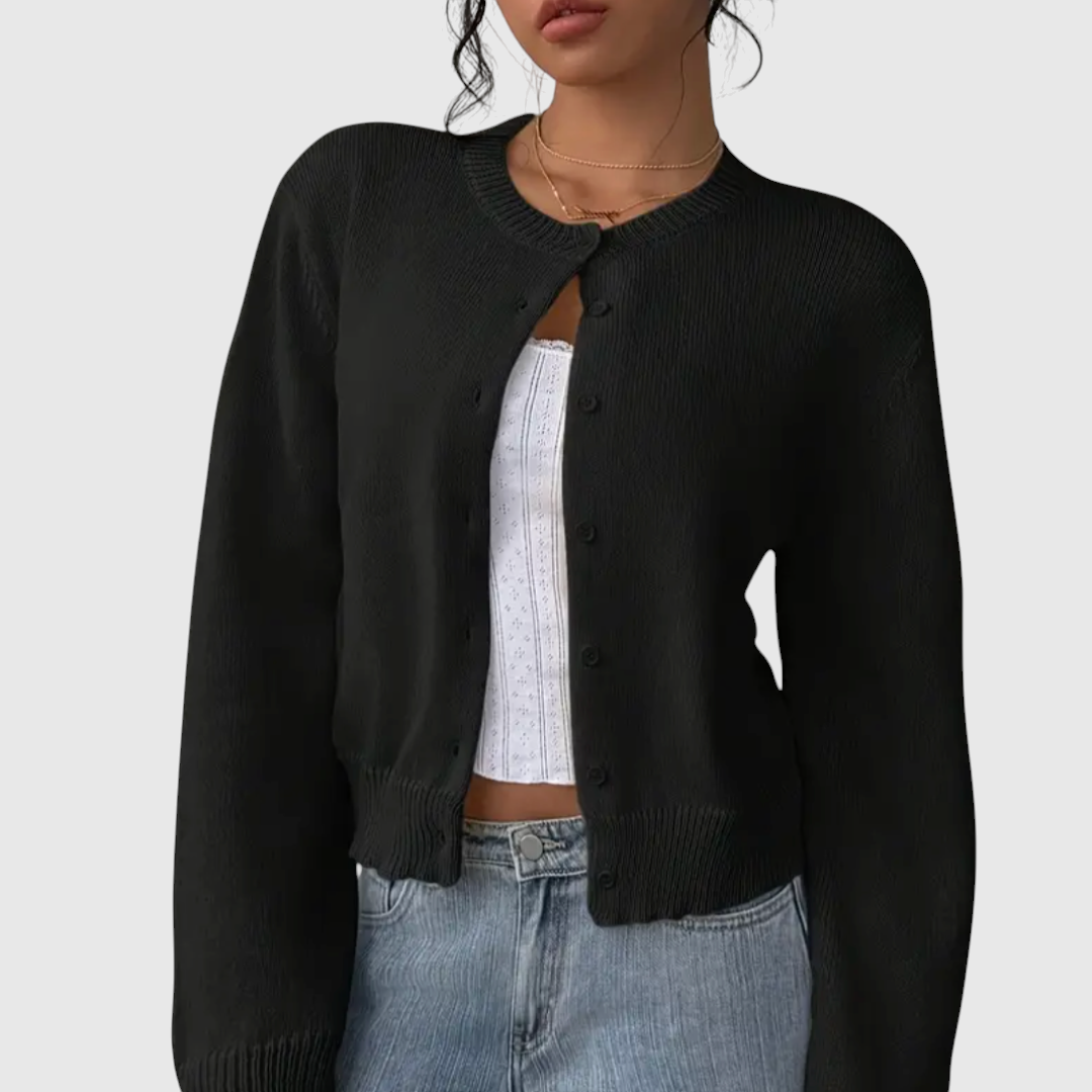 My Store Angelika black cropped knit cardigan with a round neckline and button-down front worn over a white top.